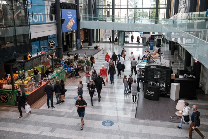 Ihmisiä kävelemässä ja asioimassa valoisassa ostoskeskuksessa