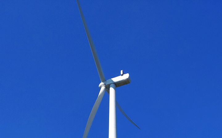 Tuulivoimala kirkasta sinistä taivasta vasten.