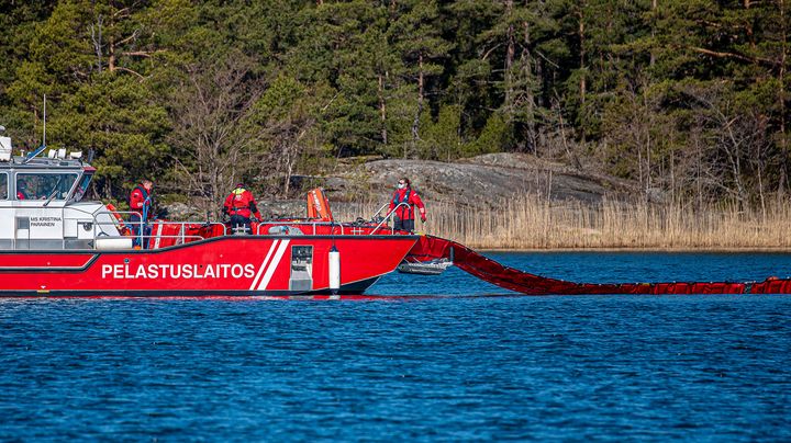 Ett fartyg från Egentliga Finlands räddningsverk sänker ner oljelänsor i havet