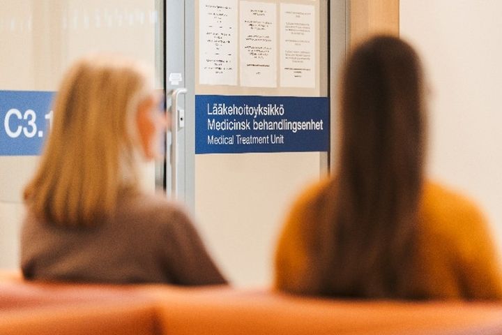 Kaksi henkilöä lääkehoitoyksikön odotushuoneessa