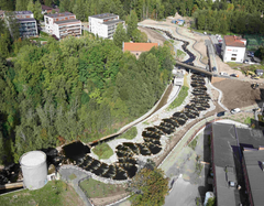 Ilmakuva Kankaan uudelta keskusta-alueelta: koski, rakennustyömaa ja uusia asuinkerrostaloja metsän reunassa.