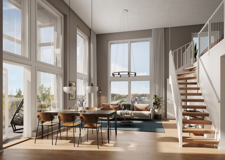 Kaunis ja valoisa T2H:n loft-asunnon olohuone, jossa katto korkealla, isot ikkunat, ruokailuryhmä ja portaikko.