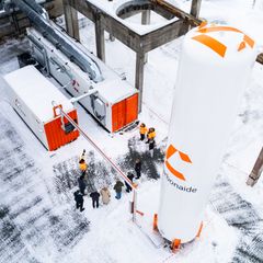 Ilmakuva teollisuuslaitoksesta talvisessa ympäristössä, jossa näkyy Carbonaiden teknologiaa edustava suuri, valkoinen säiliö ja rakennukset.