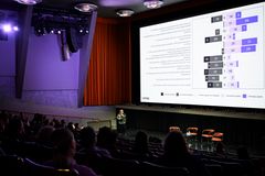 Teatterisali, jossa valkokankaalla palkkikuvio kulttuuripolitiikan barometrin vastauksista.