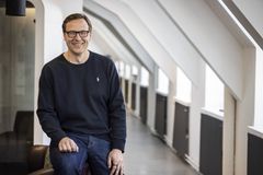 Mies katsoo kameraan hymyillen.