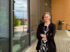Daniela Kalpala, Secton uusi kaupallinen johtaja, hymyilee kameralle modernin toimitilan edustalla, kädet rinnan päällä ristissä ja yllään musta bleiseri.