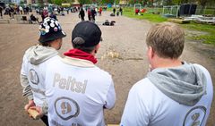 Mölkkypelaajia kuvattuna takaapäin pelikentän laidalla taktiikkapalaverissa SM-kisatapahtumassa.