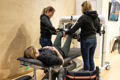 Fysiolinen osastolla näytetään miten jalkojen kuntoutuslaite käytännössä toimii. Laitetta kokeilemassa Heidi Foxell.