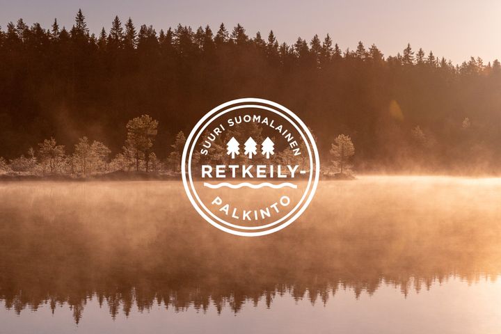 Suuri suomalainen retkeilypalkinto -logo taustanaan utuinen järvimaisema