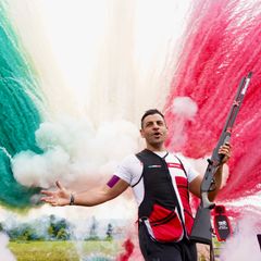Davide kädet levitettynä takanaan savupilvi Italian väreissä.