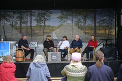 Panelistit ohjelmalavalla, etualalla näkyy ihmisiä katsomossa.
